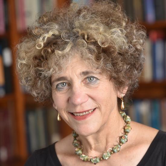 Johanna Drucker Headshot of Johanna Drucker wearing a black top and necklace against a bookshelf. Image courtesy of Johanna Drucker.