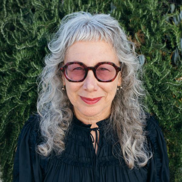 2022 AIGA Medalist Louise Sandhaus. Image courtesy of Louise Sandhaus. Photo credit: © Moira Tarmy Headshot of 2022 AIGA Medalist Louise Sandhaus wearing a black top and sunglasses against an outdoor setting. Image courtesy of Louise Sandhaus. Photo credit: © Moira Tarmy